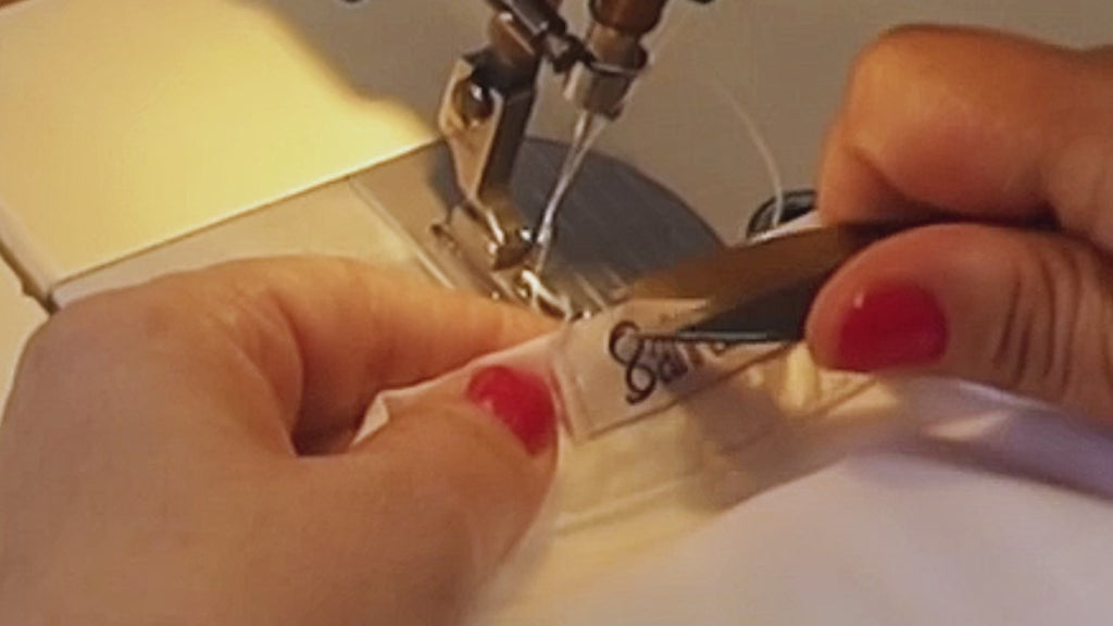 Close-up on artisan sewing label inside a Sahra.Nko corset swimsuit – Made in Italy